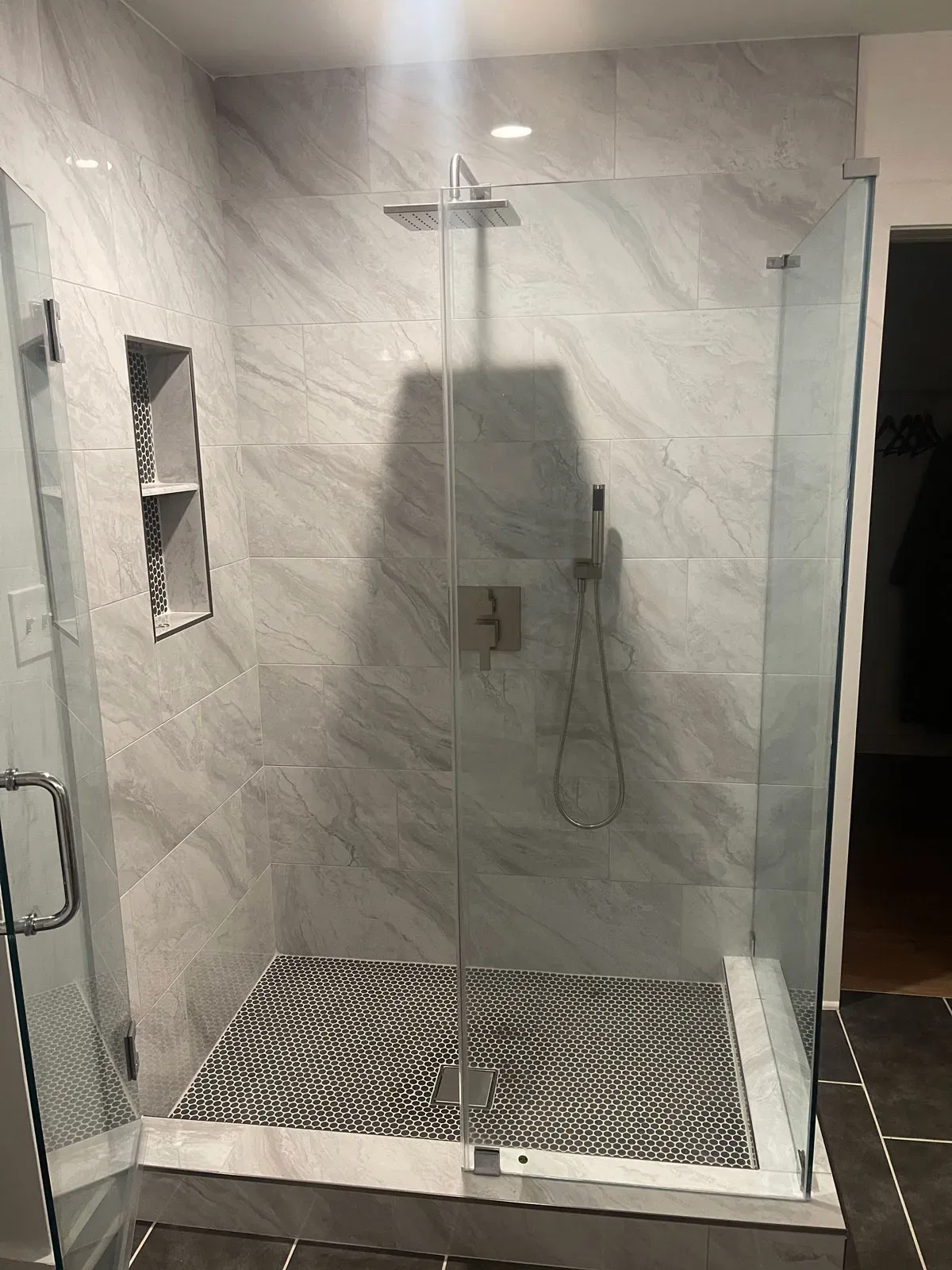 Modern marble-tiled walk-in shower with glass door